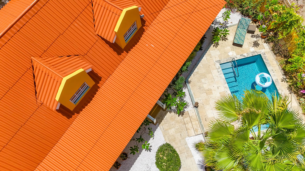 Close aerial of the dormer windows and poolside travertine deck