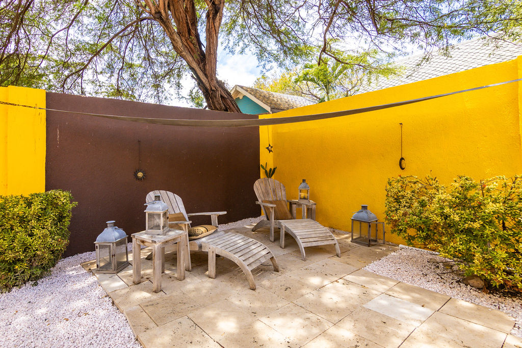 Shaded courtyard with teak loungers and lanterns under the mesquite tree