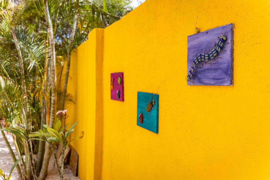 Colorful insect art on the yellow garden wall