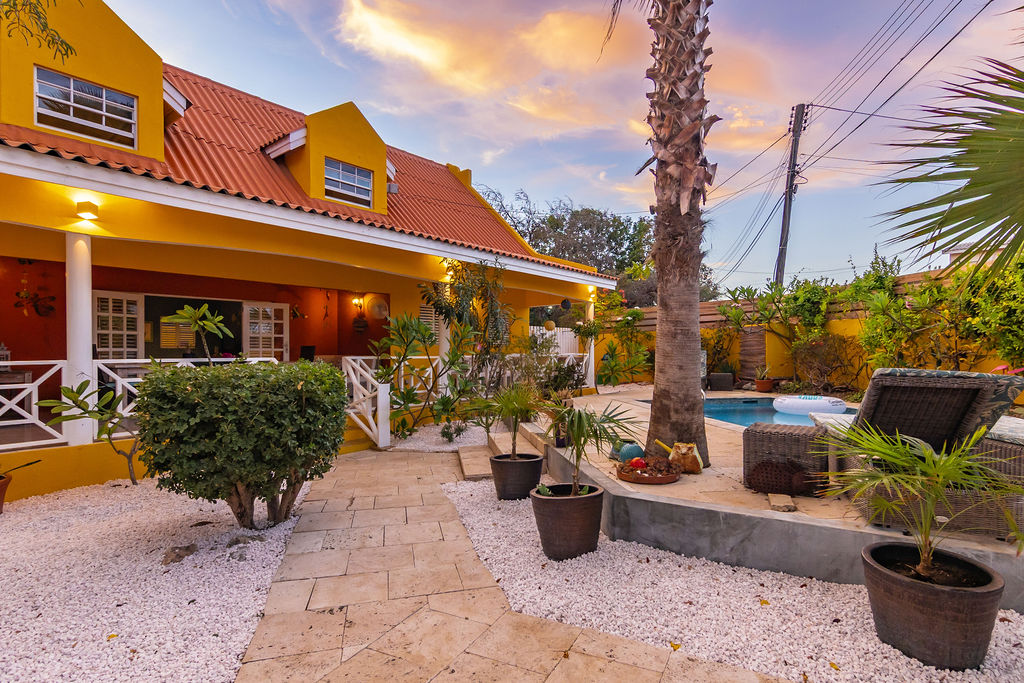 Villa veranda and poolside glowing at dusk