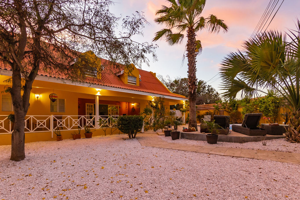 Pastel sunset behind the villa, palms and travertine path