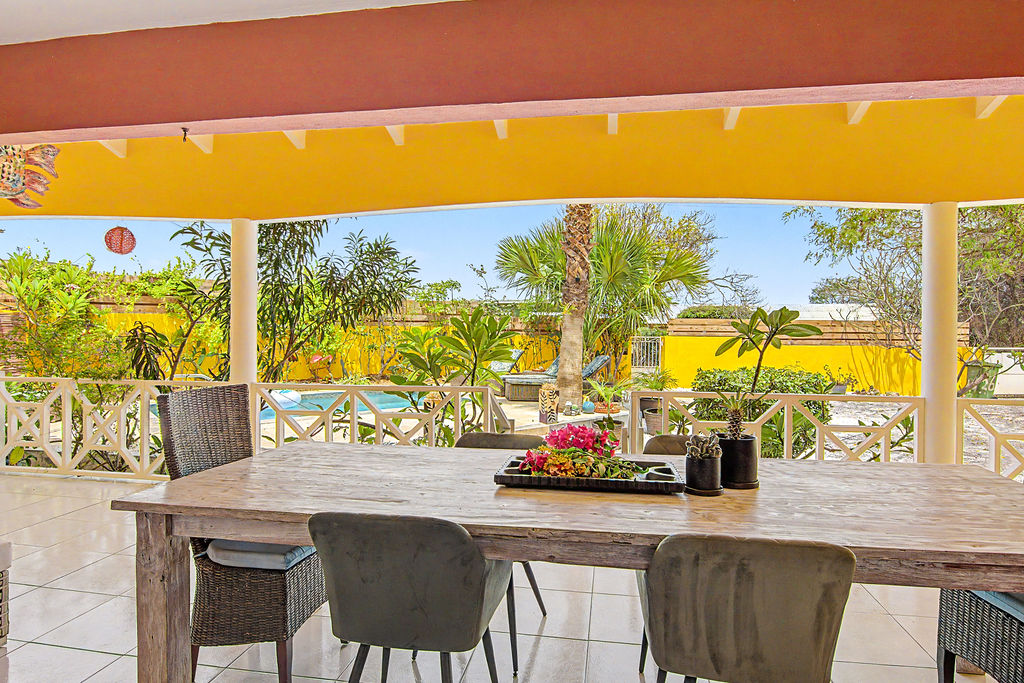 Outdoor dining table with palm and pool backdrop